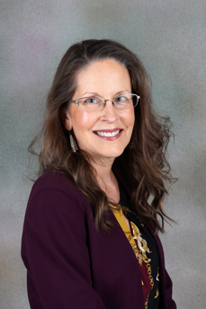 Laura Lowry poses for a professional headshot for her new role as Community Office Manager